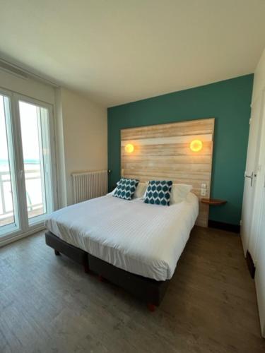una camera con un letto con due cuscini sopra di Alba hotel a Saint Malo