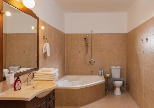 a bathroom with a tub and a toilet and a sink at Renovated Historical Roof Top Apt by the Beach in Tel Aviv