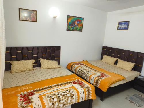 two twin beds in a room with two beds sidx sidx sidx at Omaxe eternity in Vrindāvan