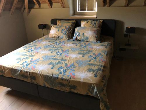 a bed with a blue and white blanket and pillows at La conciergerie in Namur