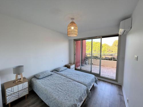 une chambre avec un lit et une grande fenêtre dans l'établissement Rooftop Villeneuve, à Villeneuve-Loubet