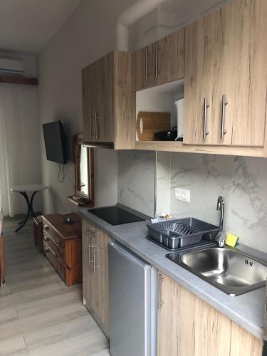 a kitchen with wooden cabinets and a sink at Athina Studios in Paleokastritsa
