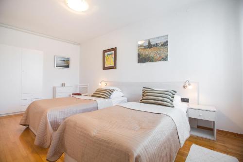 two beds in a room with white walls at Penthouse apartment with private parking in Zagreb