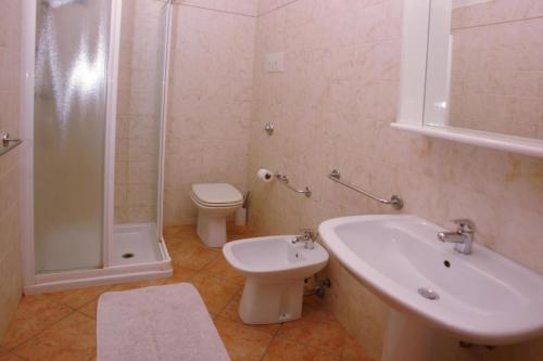 uma casa de banho com um lavatório, um WC e um chuveiro em Dreizimmerwohnung ohne Seeblick em Tignale