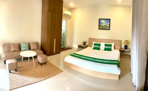 a bedroom with a large bed and a couch at LQ villa -Long Hải in Long Hai
