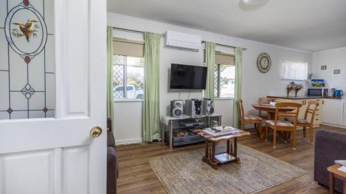 ein Wohnzimmer mit Sofa und Tisch in der Unterkunft Lowset, pet friendly cottage - Sunset Ave, Bongaree in Bellara