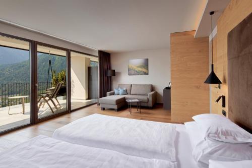 シェーナにあるLifestyle Hotel Alpinのベッドルーム1室(ベッド1台付)、リビングルームが備わります。