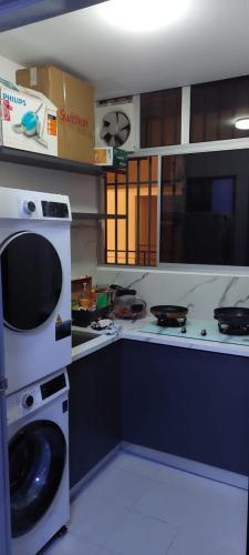 een keuken met een wasmachine en een fornuis bij SetiaWalk pusat Bandar puchong in Puchong