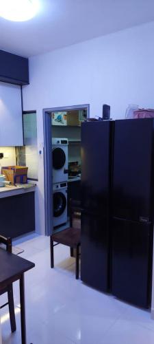 een keuken met een grote zwarte koelkast. bij SetiaWalk pusat Bandar puchong in Puchong