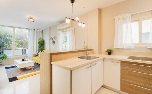 a kitchen with white cabinets and a sink at Beach Designed Apartment in Tel Aviv
