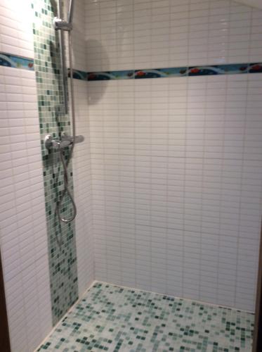 une salle de bain avec douche carrelée de blanc dans l'établissement Méditerranée paradise, à Saint-Raphaël