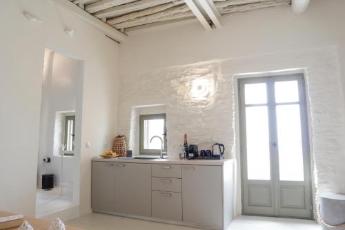 a white kitchen with a sink and a window at VILLA CALLIOPE KEA in Ioulida