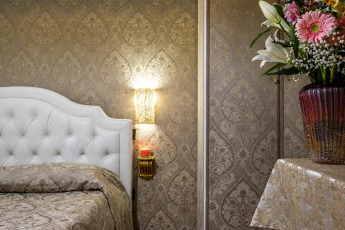 a bedroom with a bed and a vase of flowers at Hotel Apostoli Garden in Venice