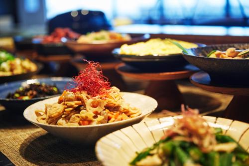 a table topped with bowls of food on a table at hotel MONday Premium Ueno Okachimachi in Tokyo