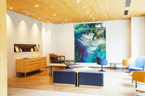 a living room with a large painting on the wall at hotel MONday Premium Ueno Okachimachi in Tokyo