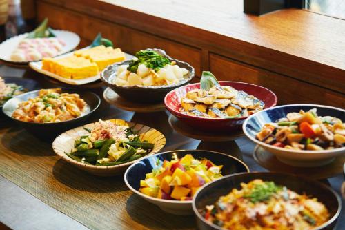 una mesa cubierta con cuencos de diferentes tipos de alimentos en hotel MONday Tokyo Nishikasai, en Tokio
