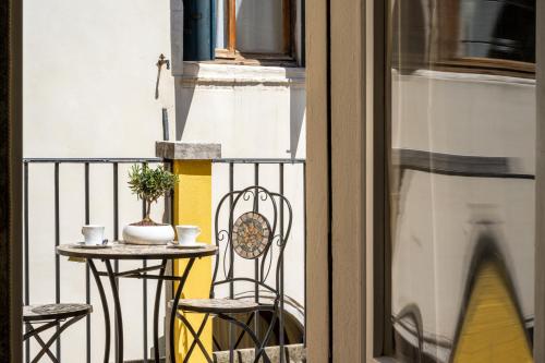 a small table and chairs on a balcony with a window at Hotel Apostoli Garden in Venice