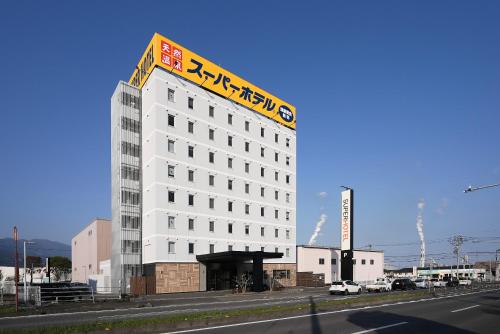 a white building with a sign on top of it at Super Hotel Shikoku-chuo in Shikokuchuo