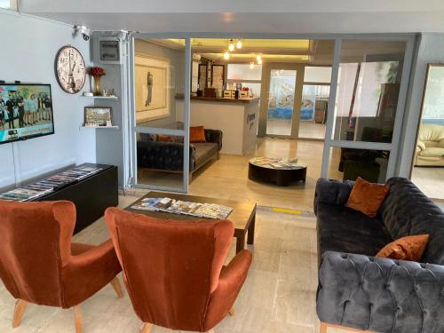 a living room with a couch and a table and chairs at Olimpia Hotel in Fethiye