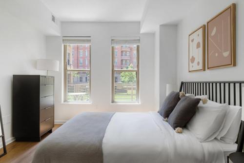 a white bedroom with a large bed and two windows at U Street 1br w gym wd nr metro dining WDC-676 in Washington