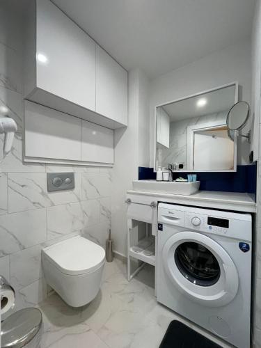 a bathroom with a toilet and a washing machine at Apartments Black Sea Resort in Batumi