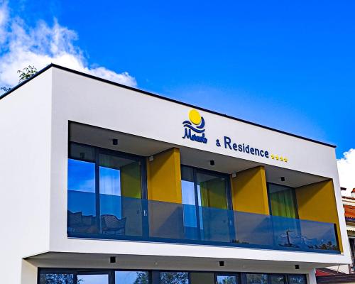 a building with a restaurant sign on top of it at Maresole Beachfront Residence in Poreč