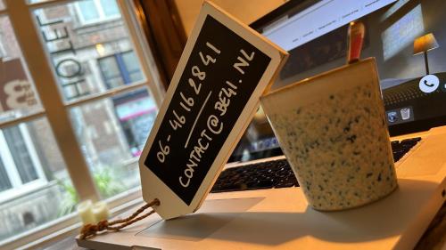 a laptop computer with a sign on top of it at BE41 Boutique Hotel in Maastricht