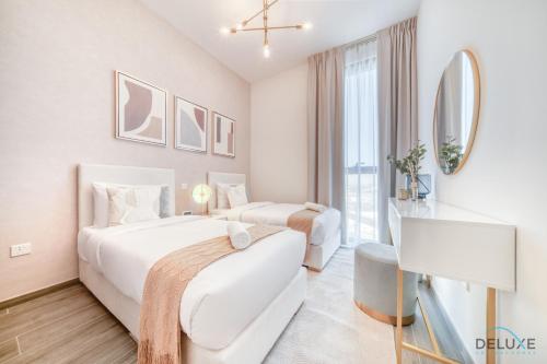 dwa łóżka w pokoju hotelowym z telewizorem w obiekcie Exquisite 2BR with Assistant Room at Mesk 1 Midtown Dubai Production City by Deluxe Holiday Homes w Dubaju