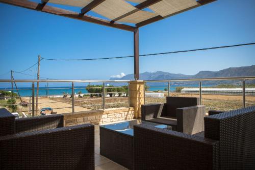 a balcony with chairs and a view of the beach at Villa Archontissa in Análipsis