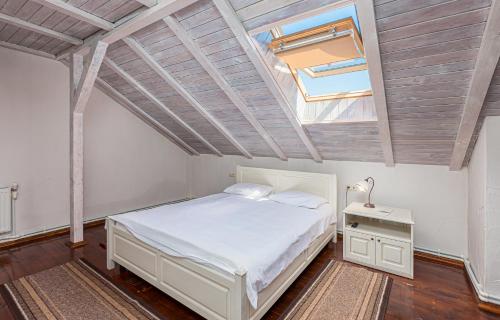 a bedroom with a white bed and a skylight at Chateau Vartely in Orhei