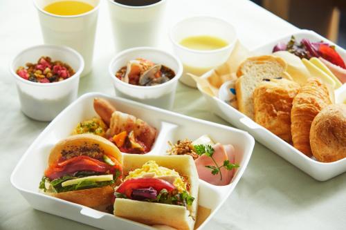 einen Tisch mit drei Tabletts Sandwiches und Dips in der Unterkunft ICI HOTEL Ueno Shin Okachimachi in Tokio