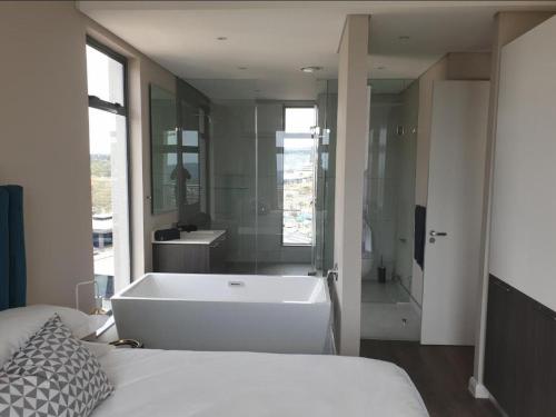 a bedroom with a bath tub and a large bathroom at Menlyn Maine Apartments in Pretoria