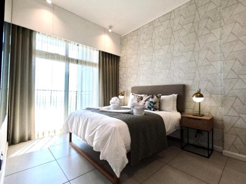 a bedroom with a bed and a large window at Menlyn Maine Apartments in Pretoria