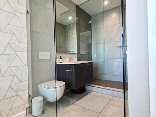a bathroom with a shower and a toilet and a sink at Menlyn Maine Apartments in Pretoria