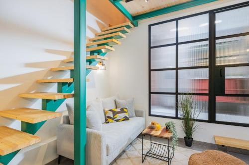 a living room with a staircase and a couch at Cozy Studio in Old Town in Tel Aviv