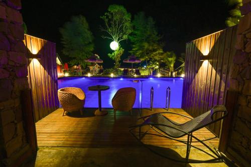a patio with chairs and a table at night at Pandora Vista Retreat in Zhangjiajie