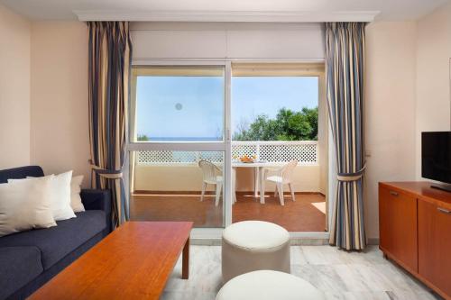 sala de estar con sofá y mesa con vistas en Pueblo Marina Summer Breeze Apartaments by Alfresco Stays, en Mijas Costa