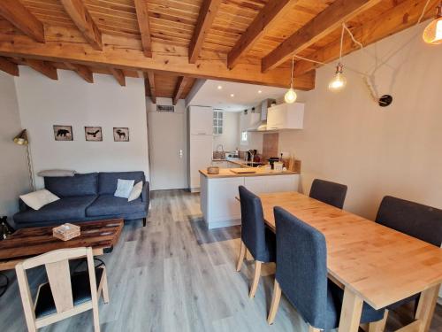 ein Wohnzimmer mit einem Holztisch und einem blauen Sofa in der Unterkunft ZAGALA LA MAISON DE LA MONTAGNE in Gèdre