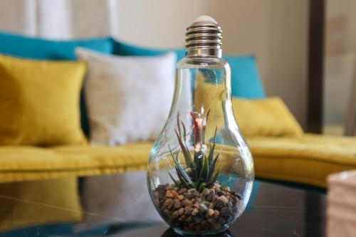 a glass bottle with a plant in it on a table at Roberta House in Áno Pavliána