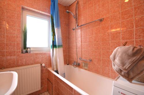 ein Bad mit einer Badewanne, einem Waschbecken und einer Dusche in der Unterkunft CO02-HI Apartment in Coburg in Coburg