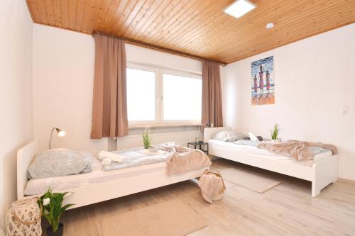 2 Betten in einem Zimmer mit 2 Fenstern in der Unterkunft CO02-HI Apartment in Coburg in Coburg