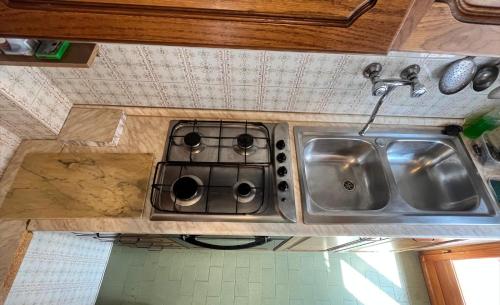 a kitchen counter with a stove and a sink at Alloggio Silvia in Lisio