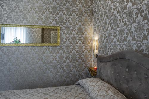 a bedroom with a bed and a mirror at Hotel Apostoli Garden in Venice