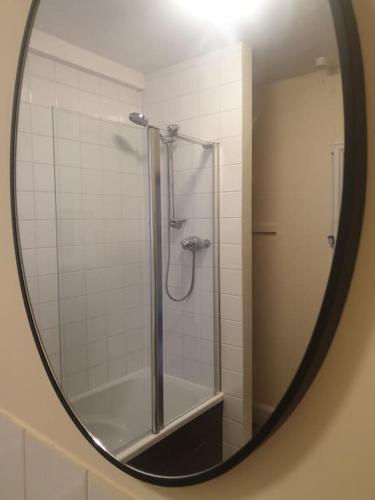 a mirror of a shower in a bathroom at Bright, spacious flat close to beach, Cliff Road in Sheringham