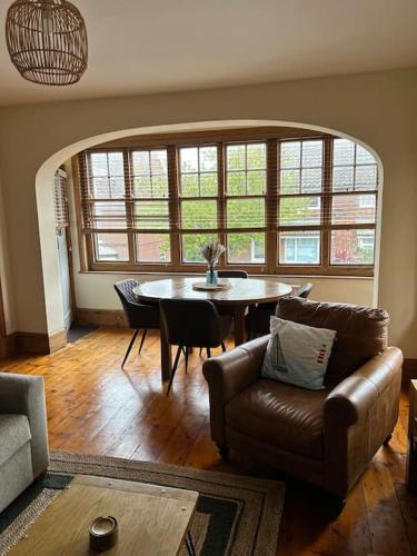 a living room with a couch and a table at Bright, spacious flat close to beach, Cliff Road in Sheringham
