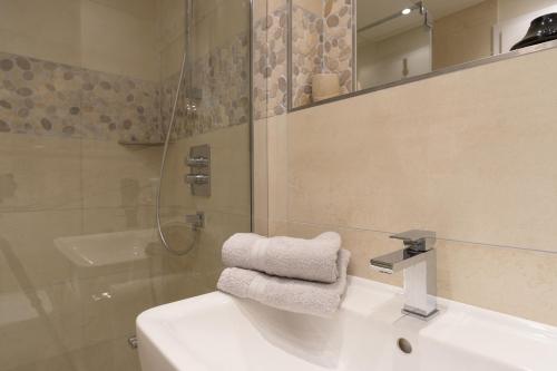 a bathroom with a sink and a shower and a towel at Fewo Schröder - Tolle in Norderney