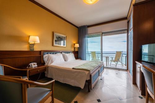 a hotel room with a bed and a balcony at Hotel Bellevue Et Mediterranée in Diano Marina