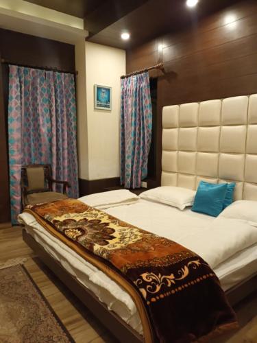 a bedroom with a large bed and a chair at Summer House in Mussoorie