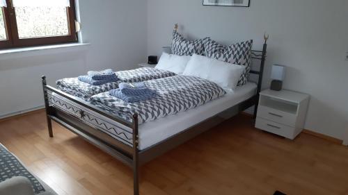a bed with a black and white comforter and pillows at Ferienwohnung-Zweiburgenblick in Runkel