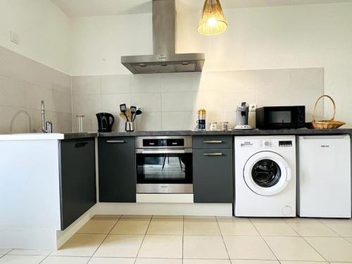 een keuken met een wasmachine en een wasmachine bij Zen et détente in Roanne